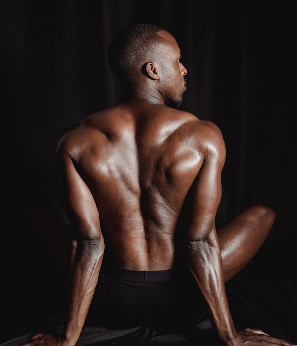 Athlete in a powerful yoga warrior pose against a dark background.